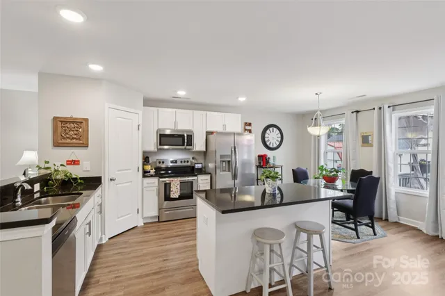 a kitchen with stainless steel appliances granite countertop a refrigerator and stove top oven