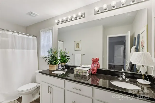 a bathroom with a double vanity sink and a mirror