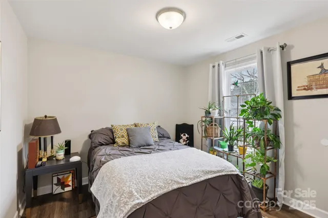 a bedroom with a bed and a potted plant