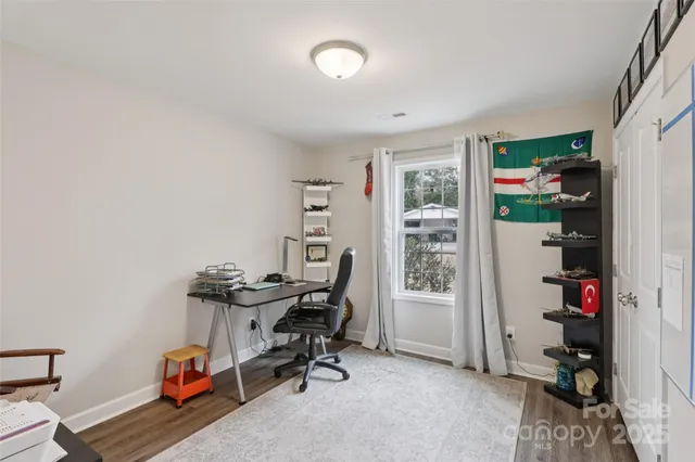 a view of a workspace with furniture and a window