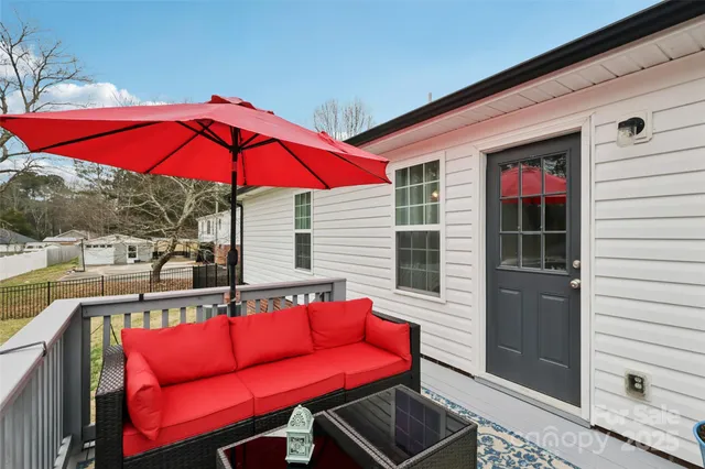 a view of a balcony with a potted plant and outdoor seating