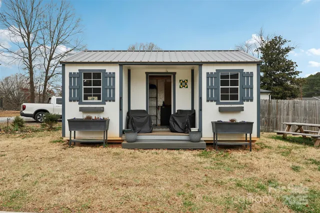 a view of house with backyard and furniture