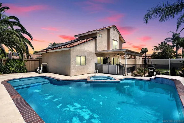 a view of a house with pool and sitting area