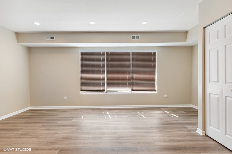 11933 South Pulaski Road, Unit 3 Alsip, IL 60803 - Photo 2 of 9 an empty room with wooden floor and windows