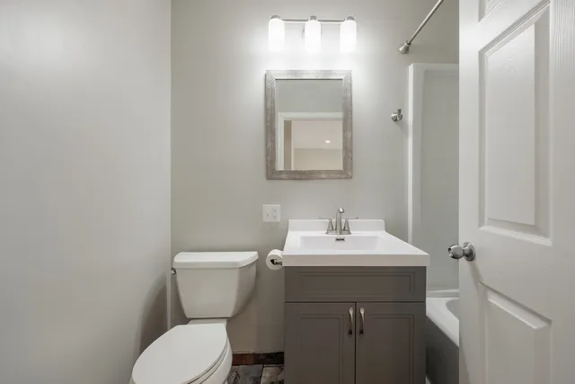 a bathroom with a toilet sink and mirror