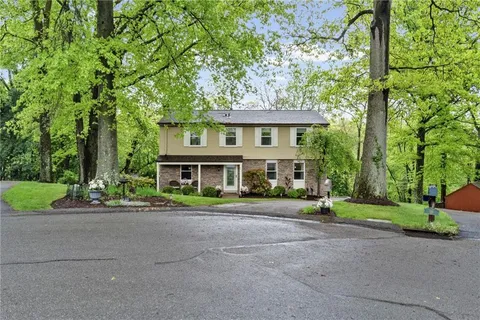 a front view of a house with a yard and trees