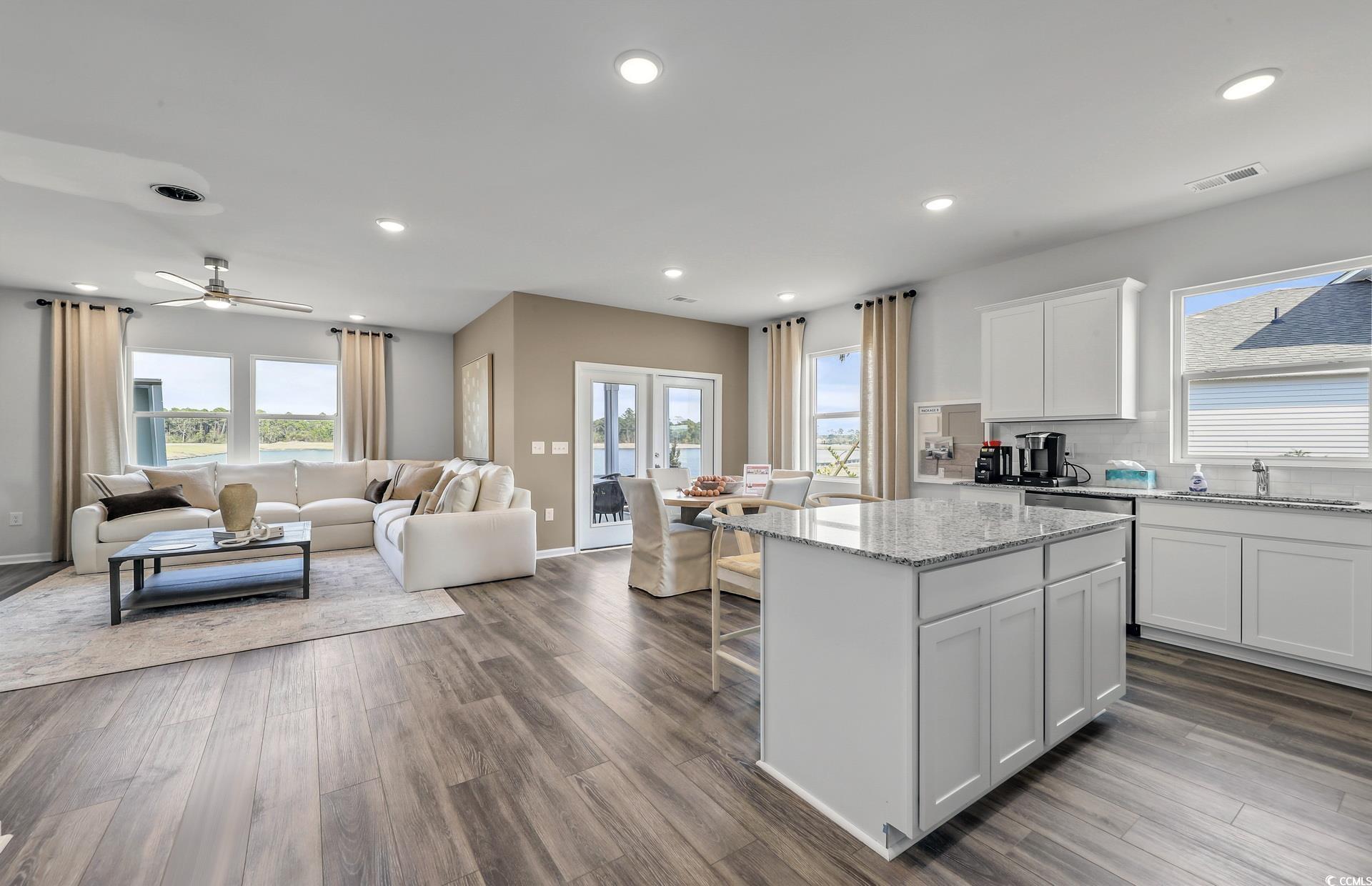 3081 Visionary Drive Myrtle Beach, SC 29588 - Photo 18 of 19 Kitchen featuring white cabinets, open floor plan, a breakfast bar, light stone countertops, and a center island