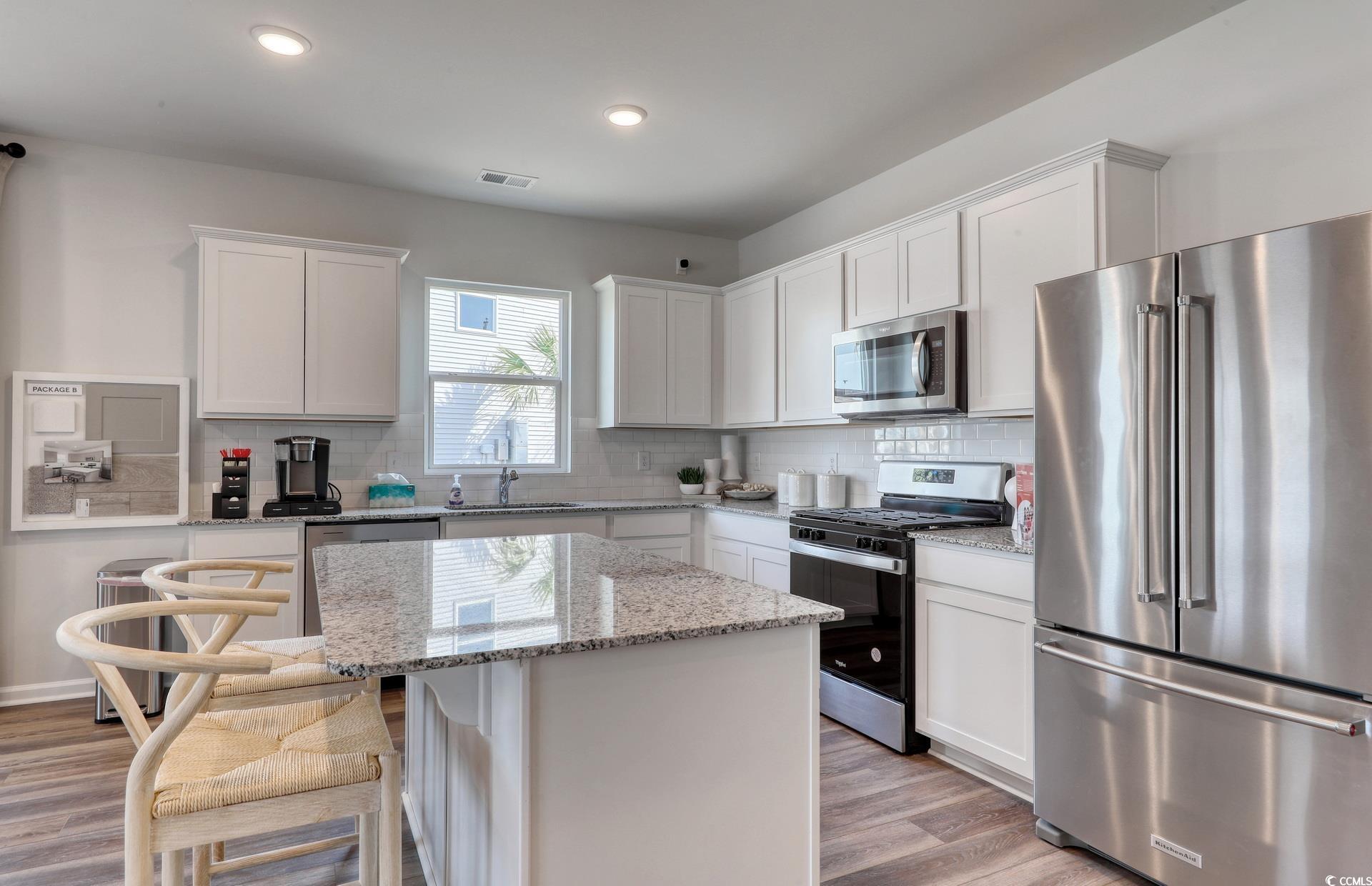 3081 Visionary Drive Myrtle Beach, SC 29588 - Photo 9 of 19 Kitchen with appliances with stainless steel finishes, white cabinetry, decorative backsplash, and recessed lighting