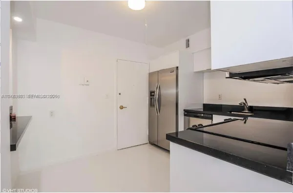 a kitchen with a refrigerator and a sink