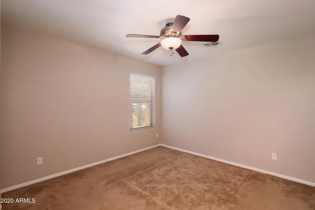 an empty room with chandelier fan