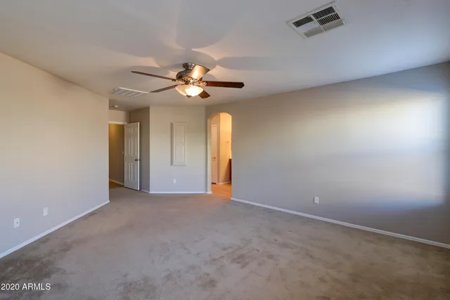 a view of an empty room with a chandelier fan