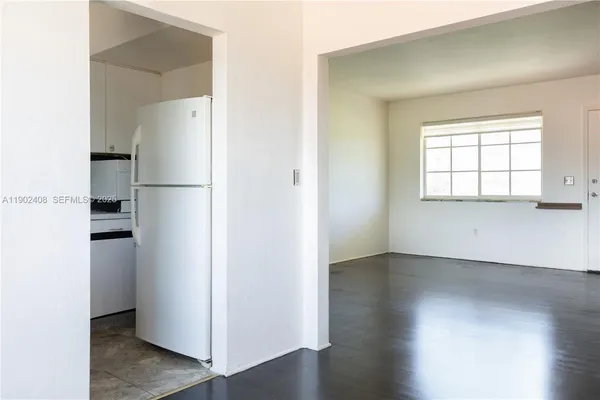 an empty room with a window and wooden floor