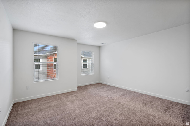 449 West 980th South Ogden, UT 84404 - Photo 19 of 23 Neutral tone carpeting in a room featuring two windows with horizontal blinds and a ceiling-mounted light fixture