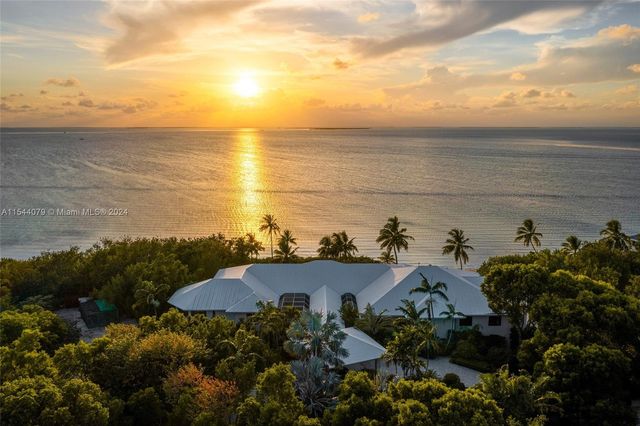 a living room with furniture kitchen view and a large window