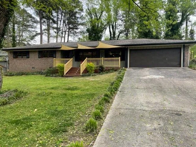 a view of a yard in front of a house with a large tree