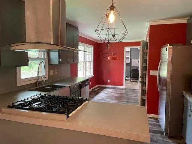 a kitchen with stainless steel appliances a stove a refrigerator and a dining table