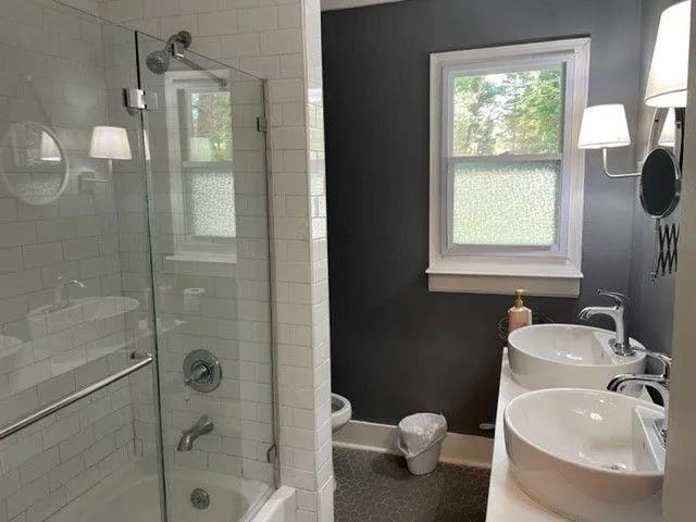 a bathroom with a sink a toilet and shower