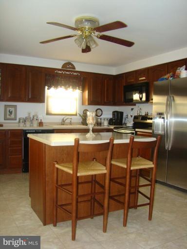16145 Sheads Mountain Road Rixeyville, VA 22737 - Photo 7 of 20 a kitchen with stainless steel appliances granite countertop a table chairs sink and cabinets