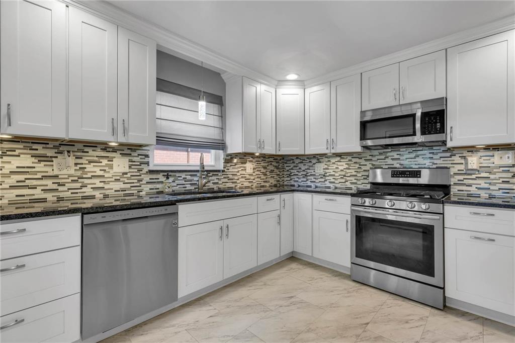 208 Gass Road Pittsburgh, PA 15229 - Photo 5 of 22 a kitchen with stainless steel appliances granite countertop a sink a stove a microwave and cabinets
