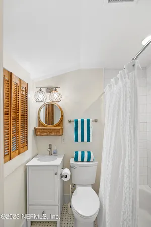 a bathroom with a sink a toilet and shower curtain