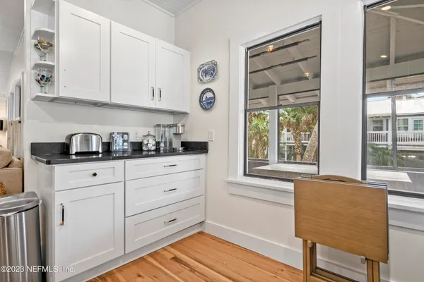 a kitchen with granite countertop white cabinets and wooden floor