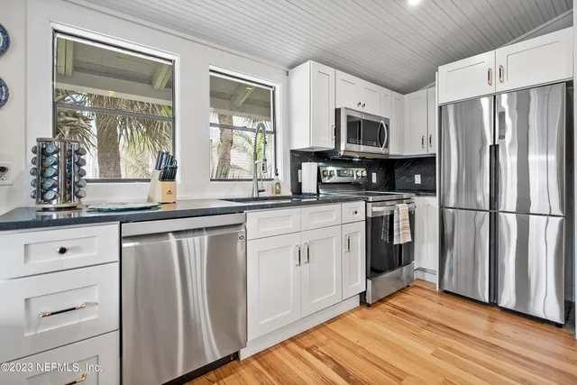 a kitchen with stainless steel appliances a refrigerator sink and microwave