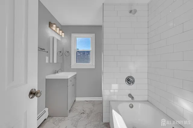 a bathroom with a tub sink and mirror