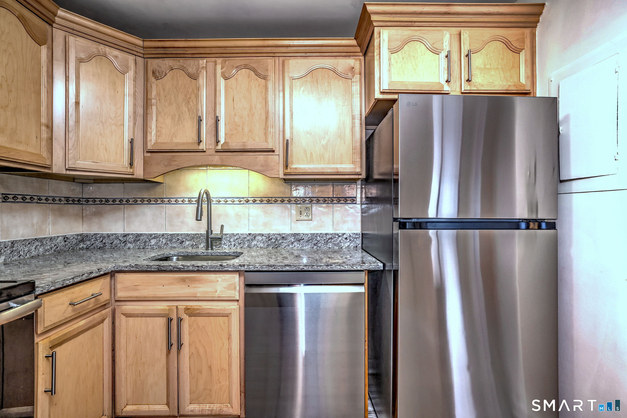 70 Putter Drive, Unit 211 Wallingford, CT 06492 - Photo 14 of 40 a kitchen with granite countertop a refrigerator and a sink