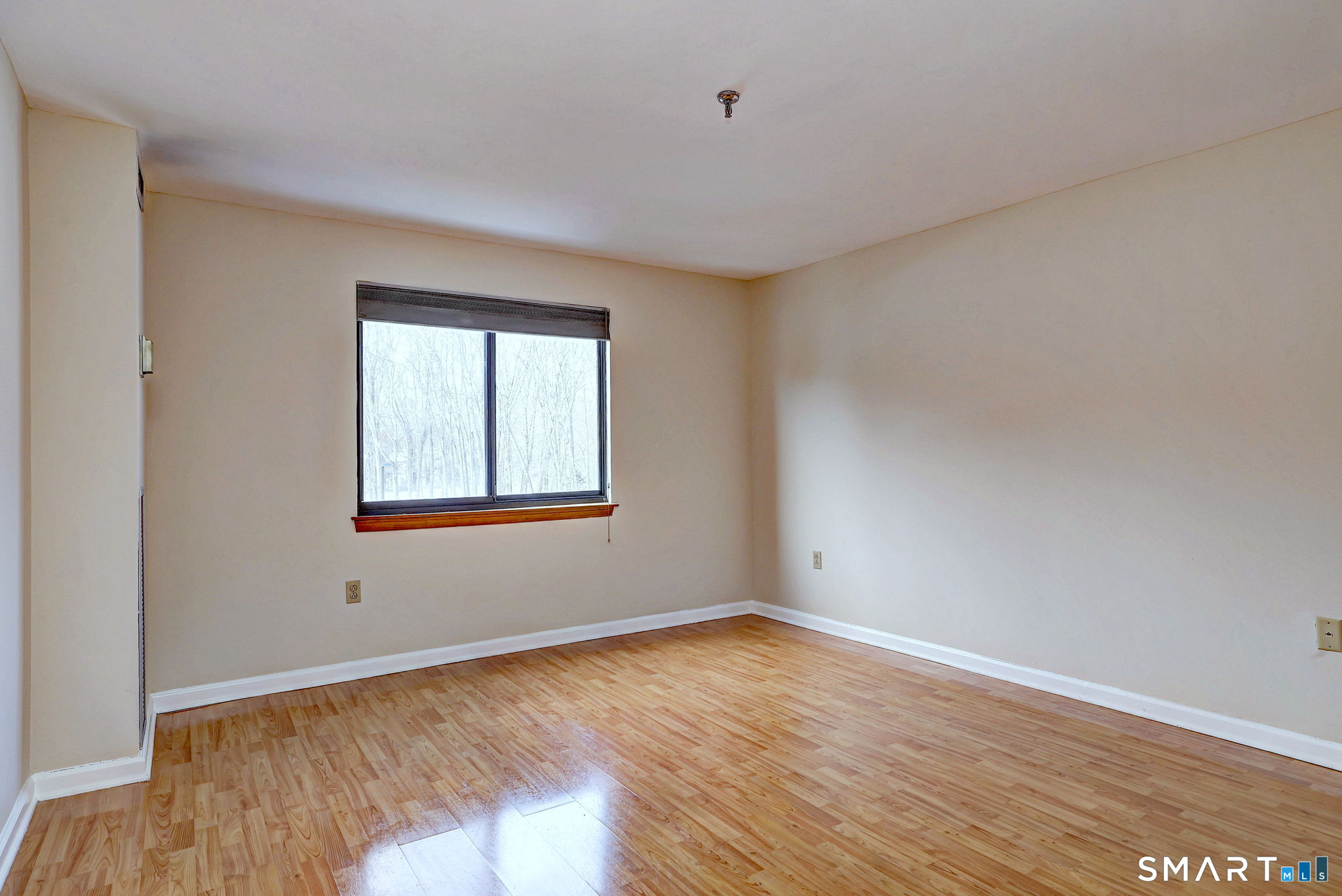 70 Putter Drive, Unit 211 Wallingford, CT 06492 - Photo 16 of 40 a view of an empty room with wooden floor and a window