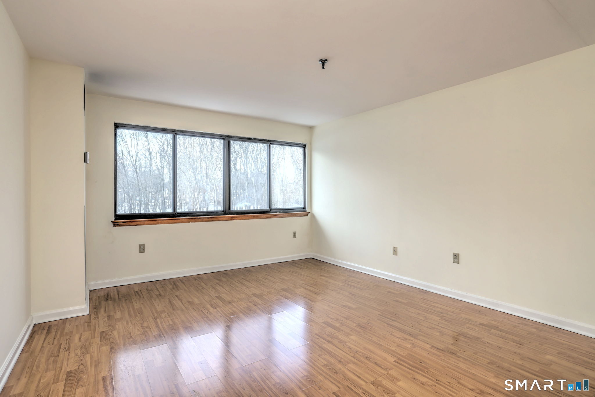 70 Putter Drive, Unit 211 Wallingford, CT 06492 - Photo 26 of 40 wooden floor in an empty room with a window