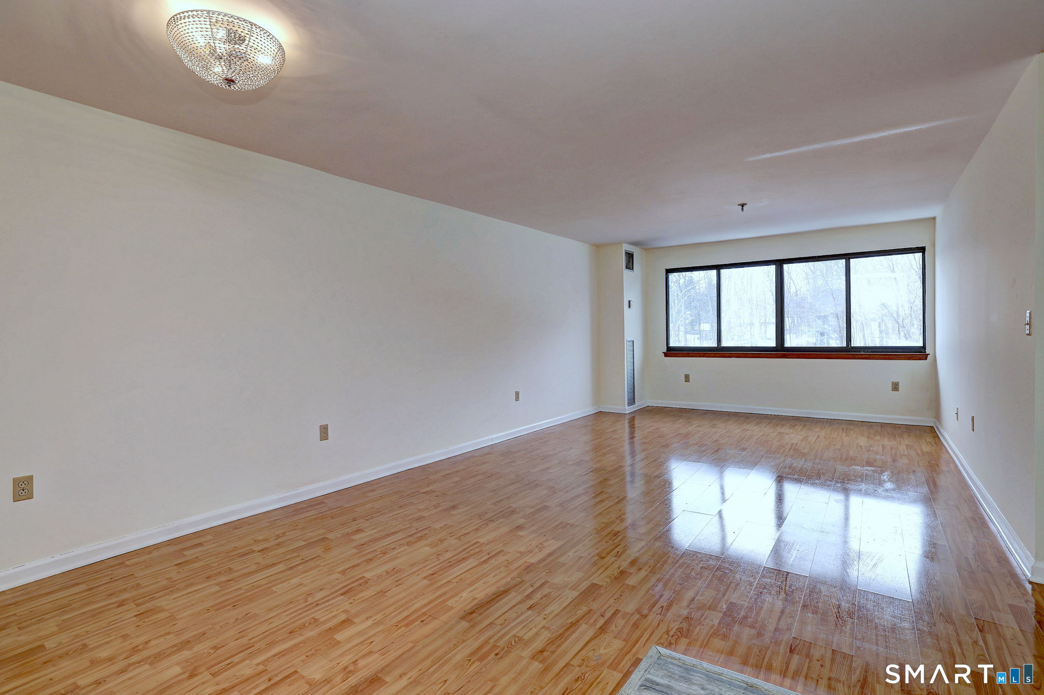70 Putter Drive, Unit 211 Wallingford, CT 06492 - Photo 3 of 40 wooden floor in an empty room with a window