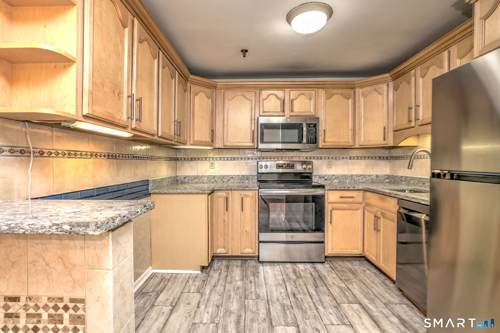 70 Putter Drive, Unit 211 Wallingford, CT 06492 - Photo 33 of 40 a kitchen with stainless steel appliances granite countertop a stove a sink and a refrigerator