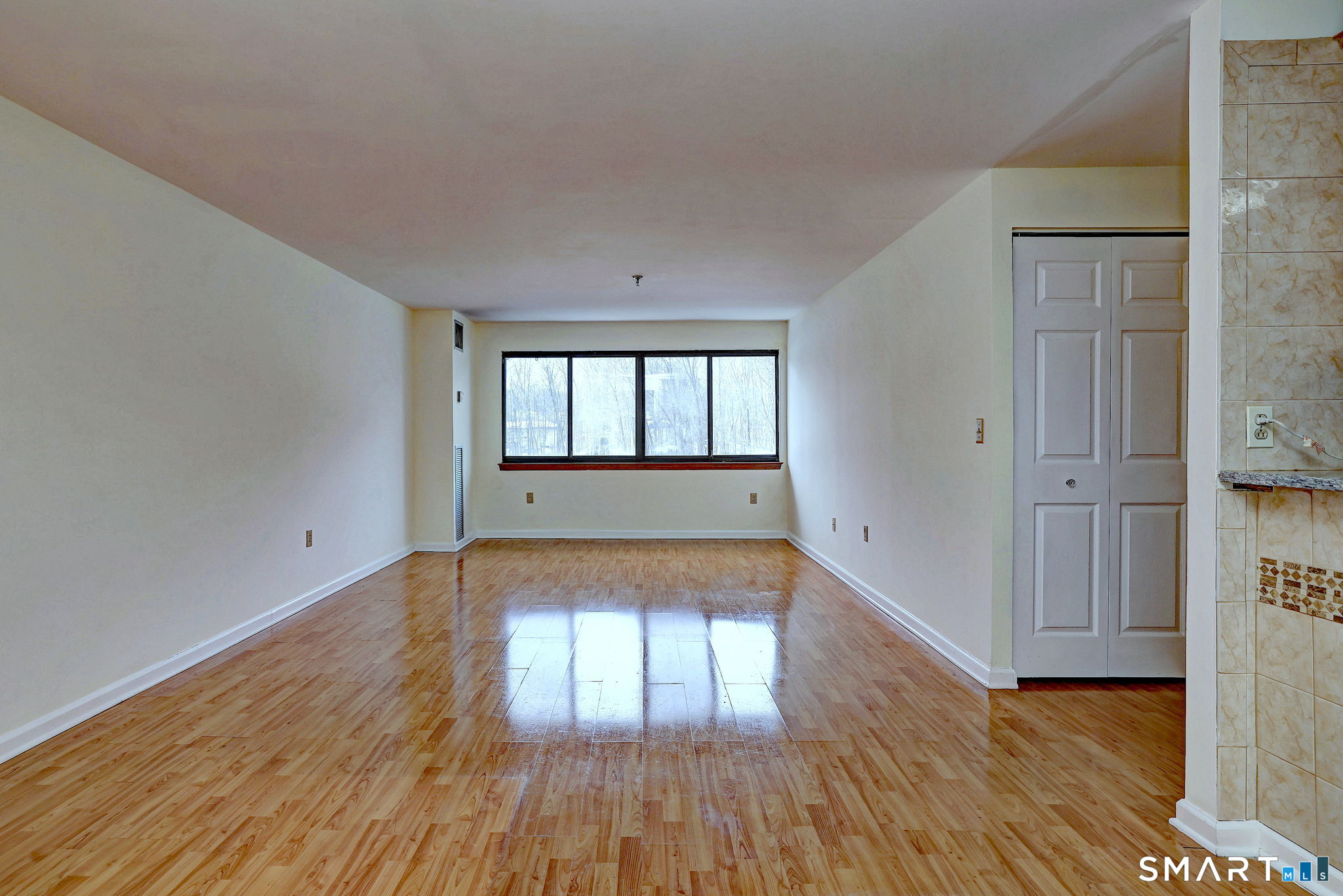 70 Putter Drive, Unit 211 Wallingford, CT 06492 - Photo 5 of 40 wooden floor in an empty room with a window