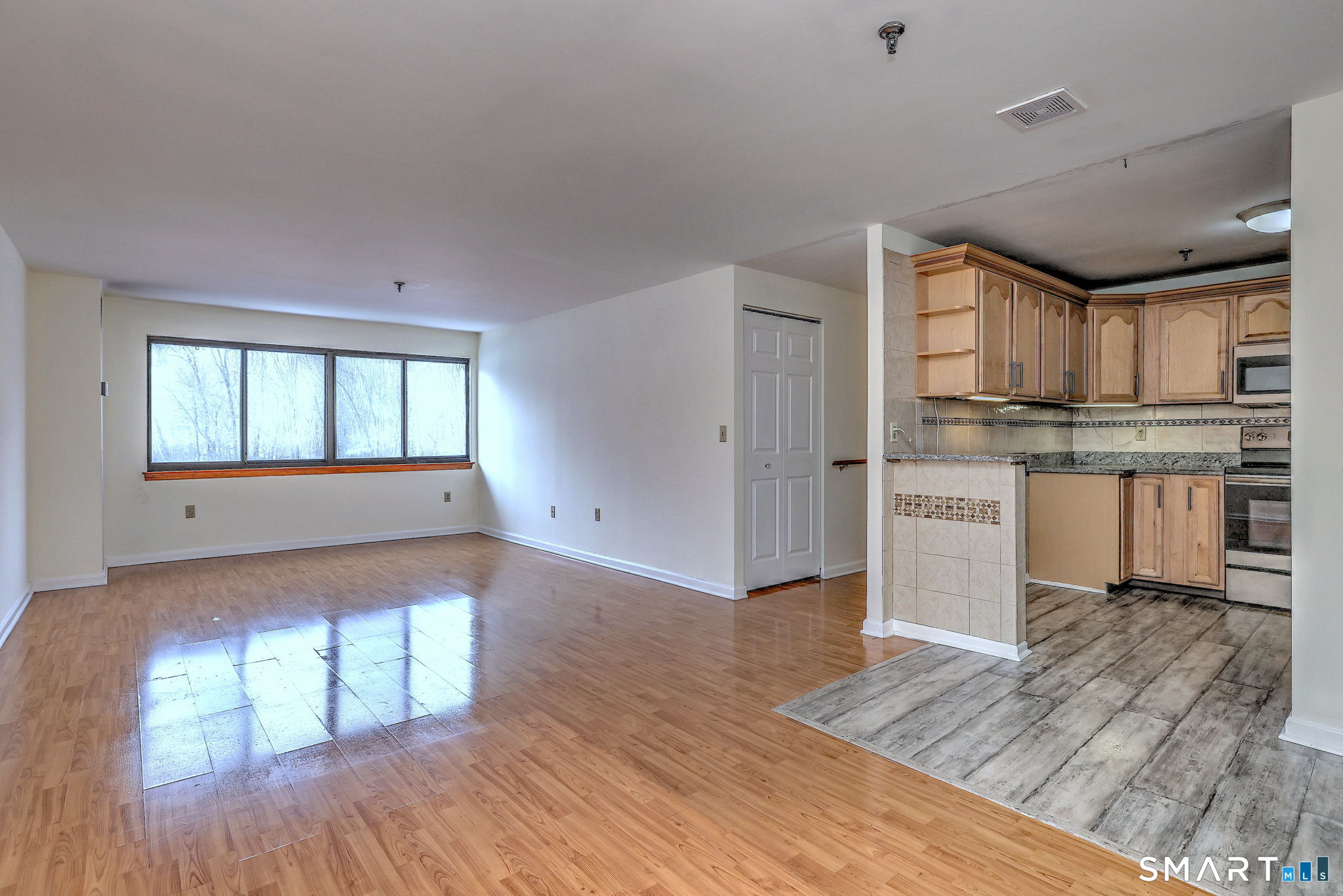 70 Putter Drive, Unit 211 Wallingford, CT 06492 - Photo 6 of 40 a kitchen with stainless steel appliances granite countertop a stove top oven a sink dishwasher and white cabinets with wooden floor