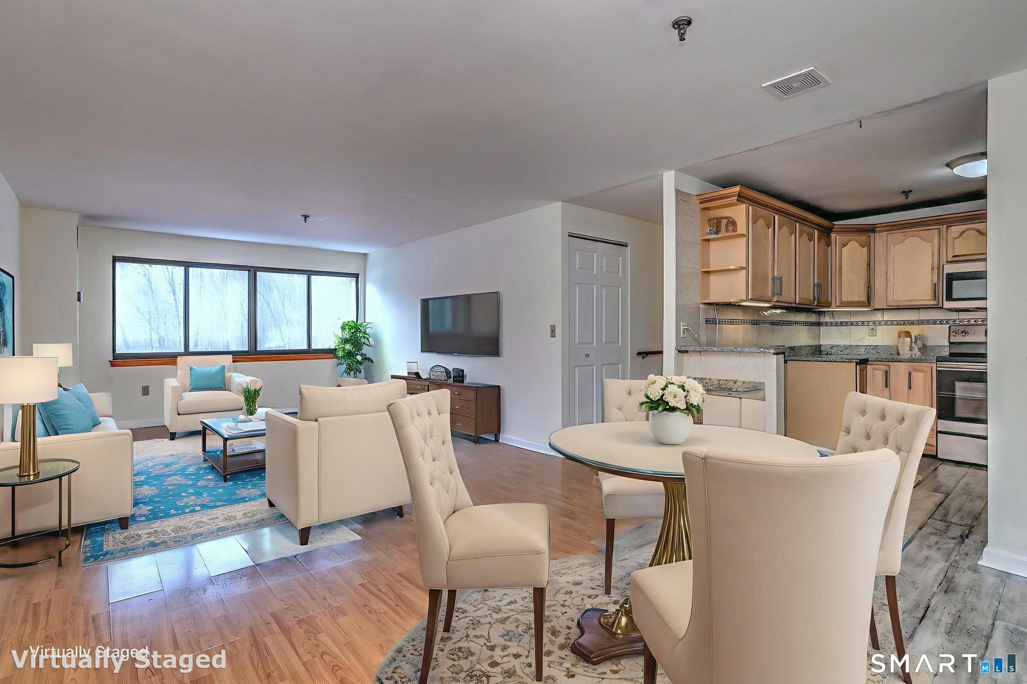 70 Putter Drive, Unit 211 Wallingford, CT 06492 - Photo 7 of 40 a living room with furniture a flat screen tv and kitchen view
