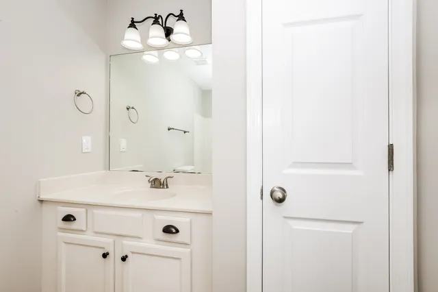 a bathroom with a sink mirror and vanity