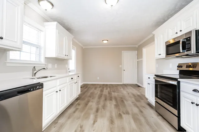 a kitchen with stainless steel appliances a stove sink microwave and cabinets
