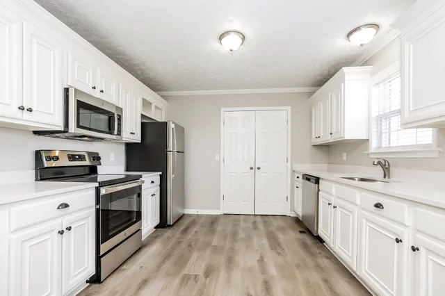 a kitchen with stainless steel appliances a stove sink microwave and cabinets