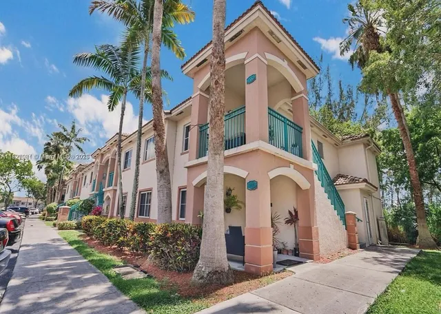 a front view of a residential houses with yard and green space