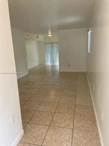 a view of a livingroom with an empty space and a window