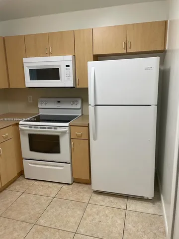 a kitchen with white cabinets and white appliances