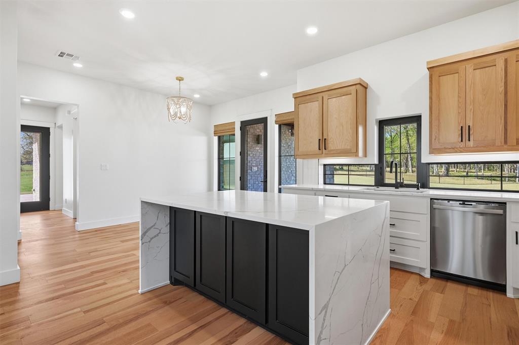 1805 Arthur Road Denison, TX 75021 - Photo 7 of 40 a kitchen with stainless steel appliances granite countertop a refrigerator a sink dishwasher and wooden cabinets with wooden floor