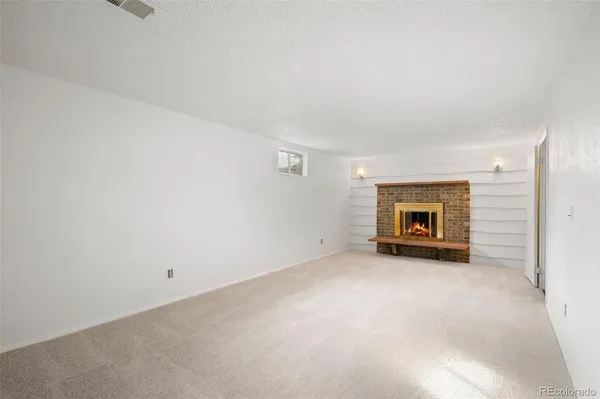an empty room with a fireplace and a window