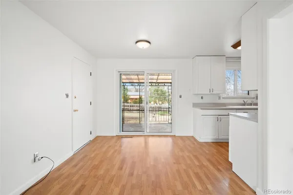 a view of a kitchen with a sink and dishwasher with wooden floor