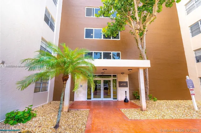 a view of a house with a small yard and potted plants