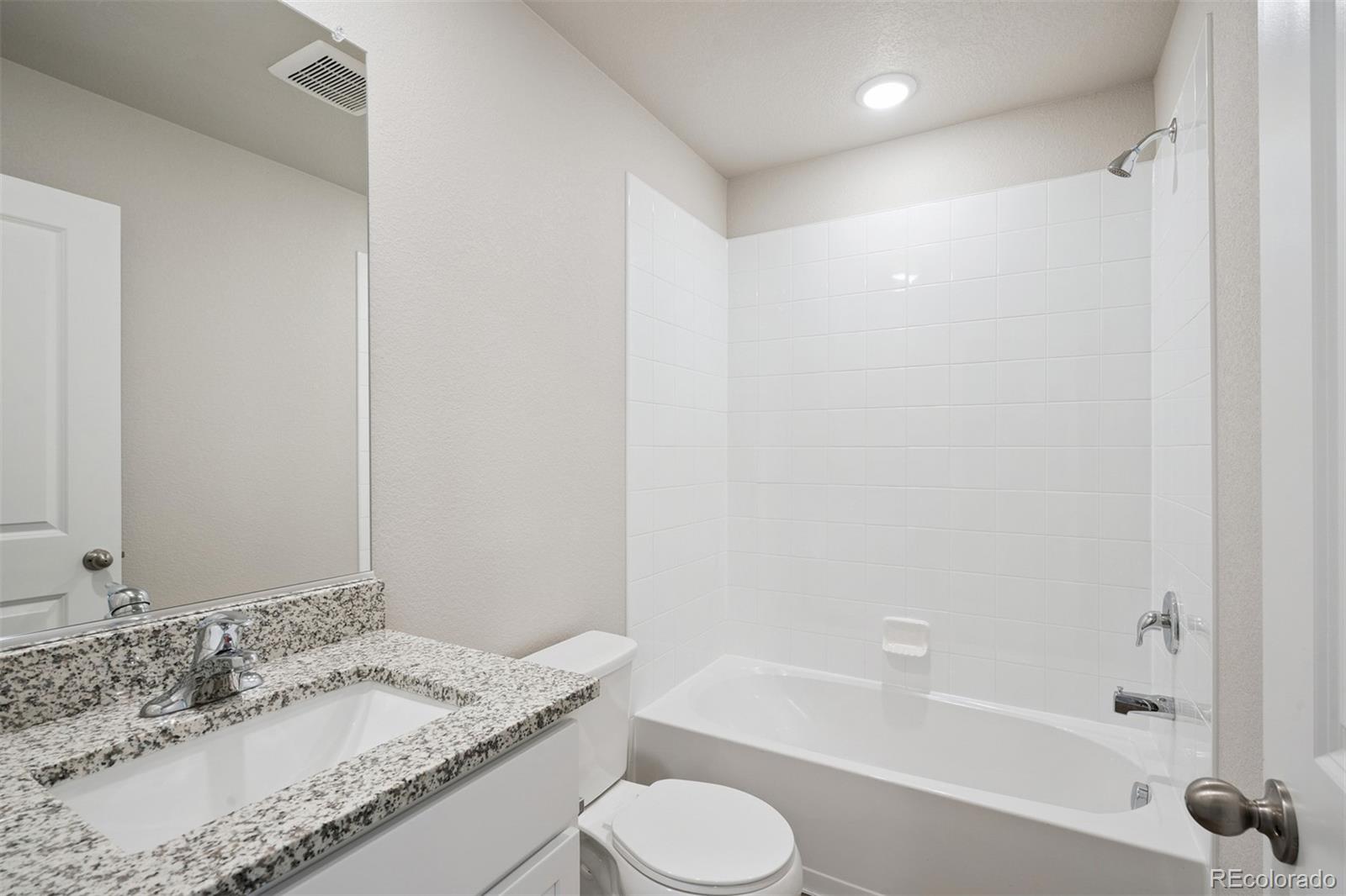 921 Montbello Avenue Fort Lupton, CO 80621 - Photo 16 of 40 a bathroom with a granite countertop sink toilet and shower