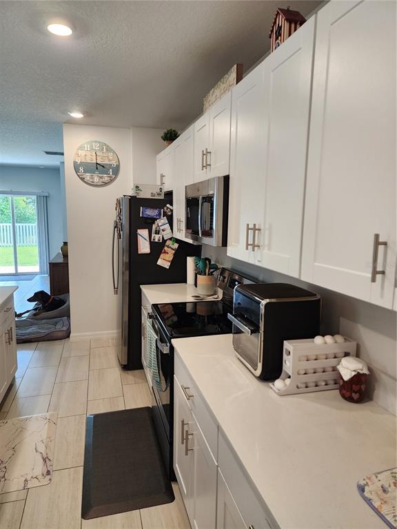 12537 Timber Moss Lane Riverview, FL 33579 - Photo 7 of 16 a kitchen with a sink a stove and cabinets
