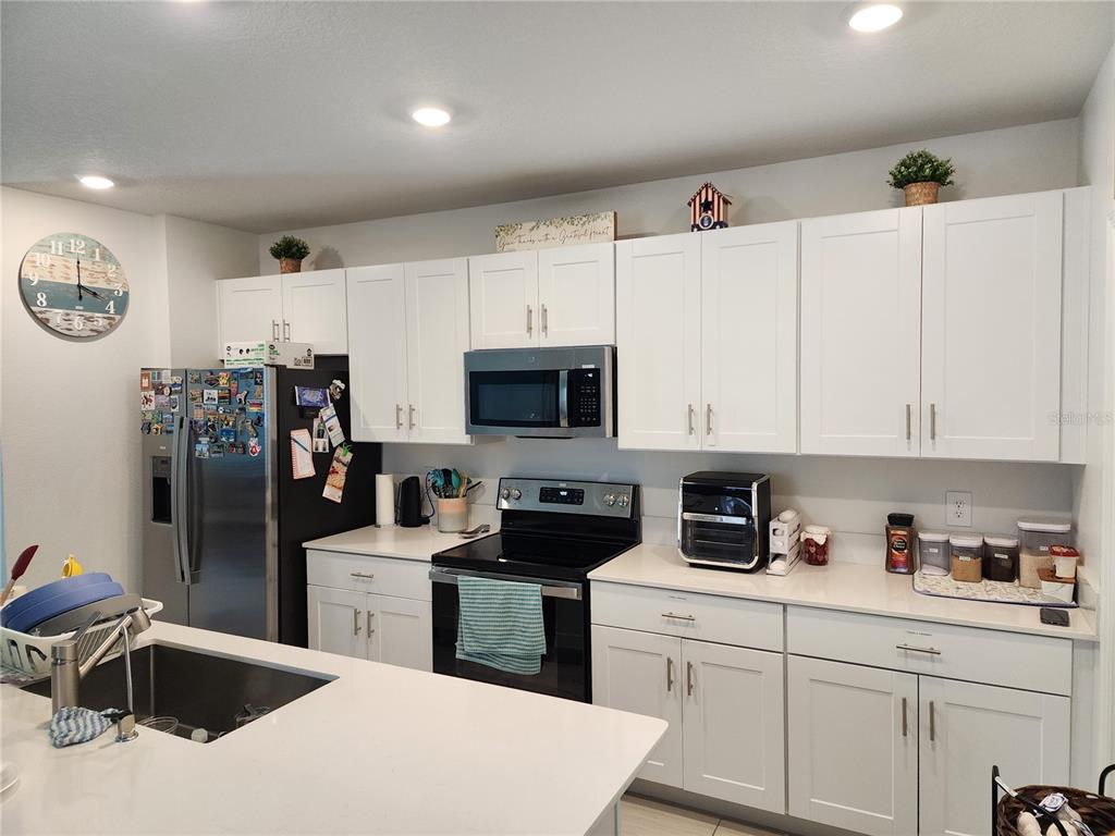 12537 Timber Moss Lane Riverview, FL 33579 - Photo 8 of 16 a kitchen with stainless steel appliances granite countertop a sink dishwasher a refrigerator and cabinets with wooden floor