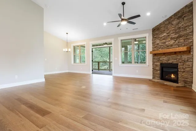 a view of an empty room with a fireplace and a window