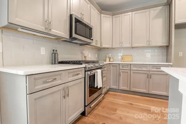 a kitchen with white cabinets stainless steel appliances and sink